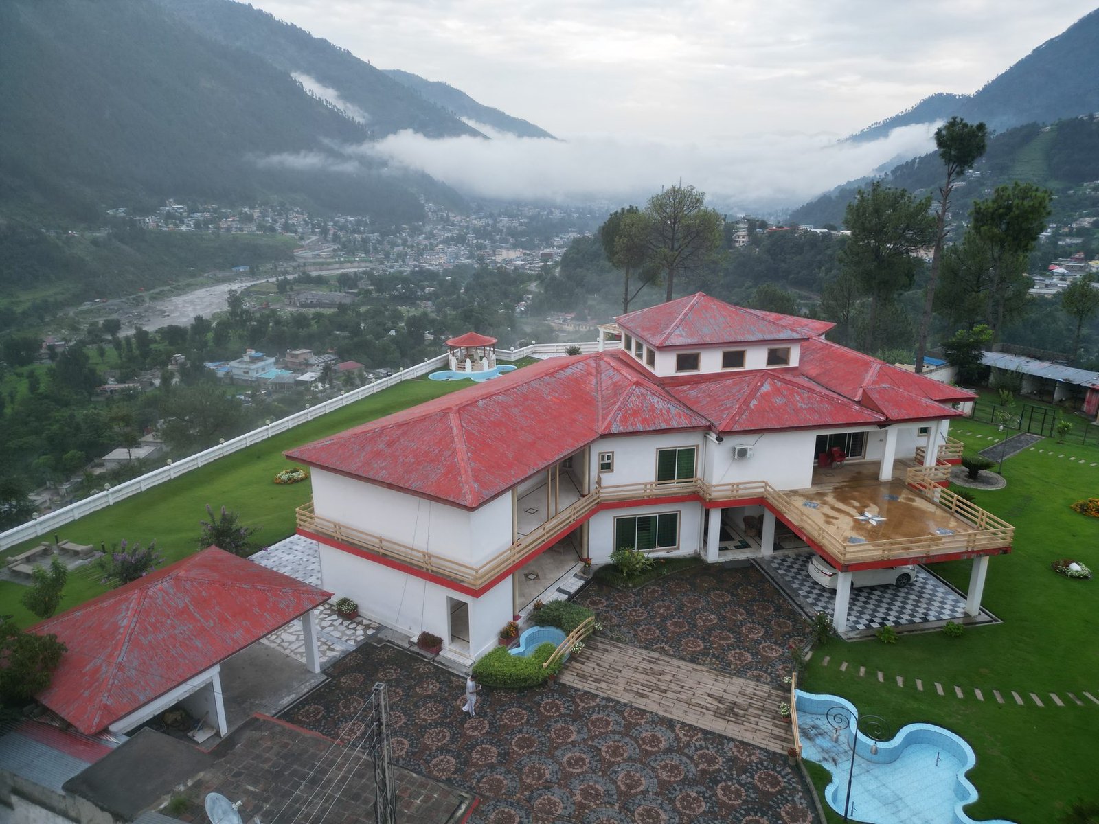 Aerial view of the lodge with misty mountains and town below