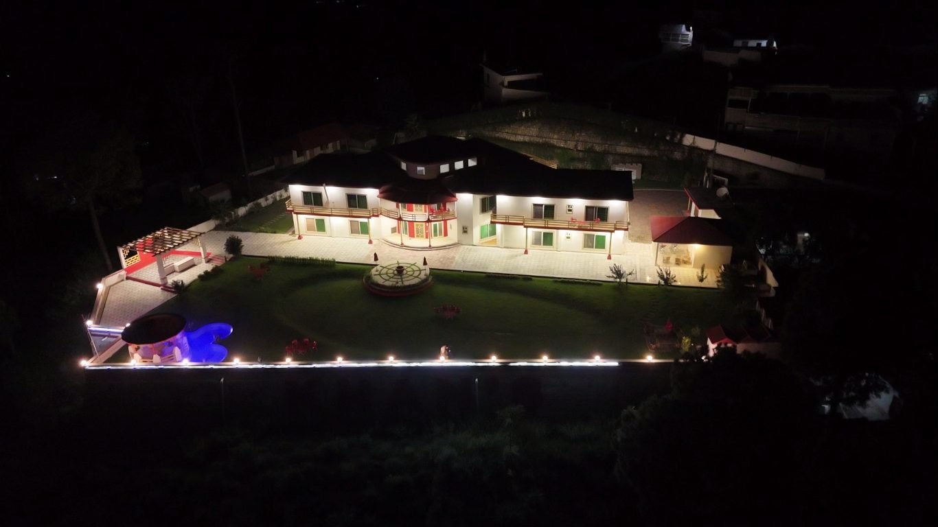 Highland Lodges Balakot lit up at night with illuminated pool and boundary lighting