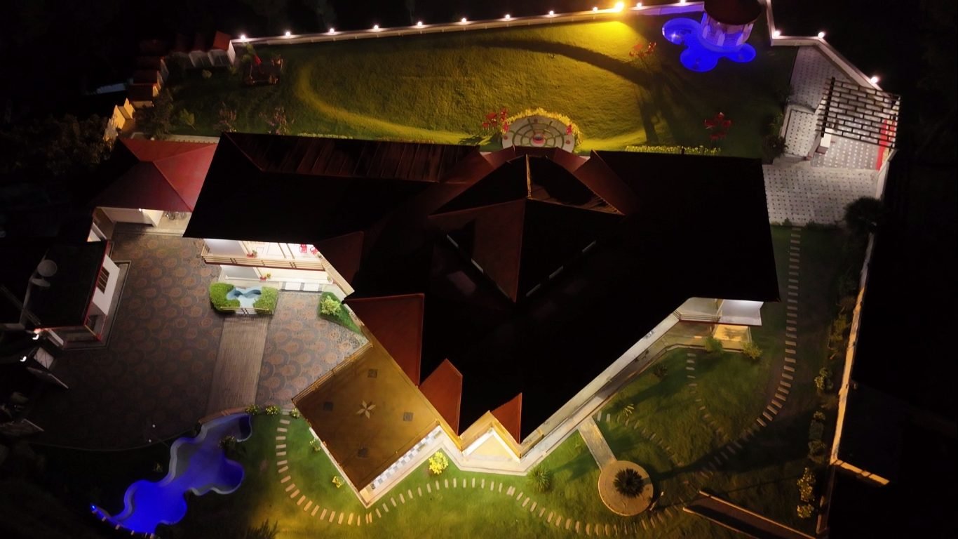 Aerial night view of Highland Lodges Balakot rooftops and glowing pool