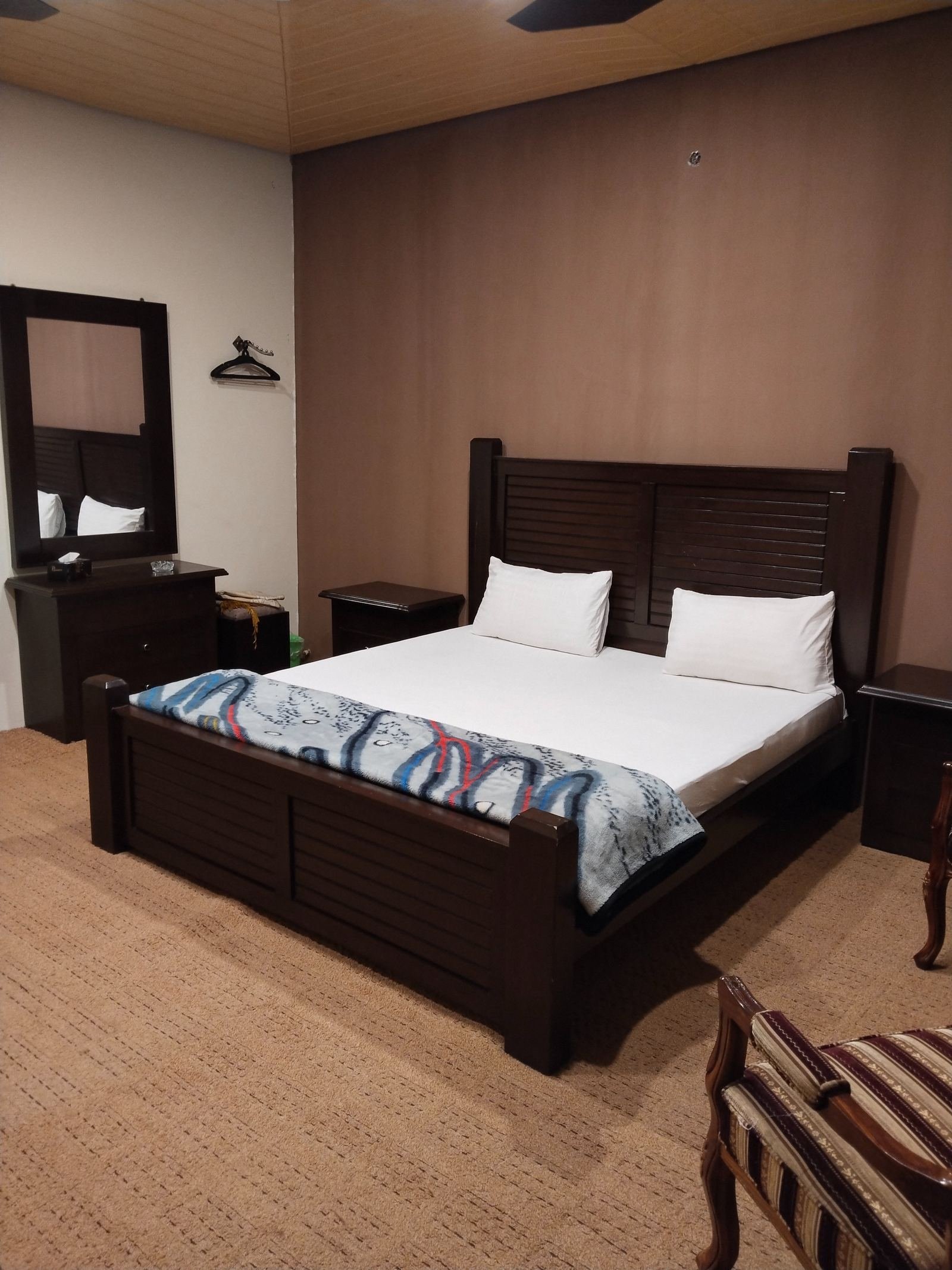 Standard Room with wooden headboard and warm interiors